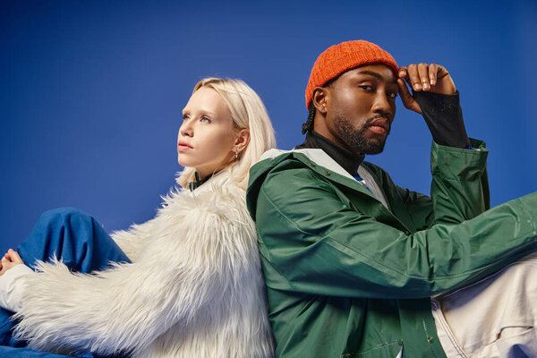 многонациональная пара, позирующая в зимнем наряде на фоне гор, африканский американец мужчина и женщина