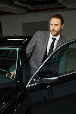 good looking professional in elegant smart suit getting into his car on parking lot, business clipart