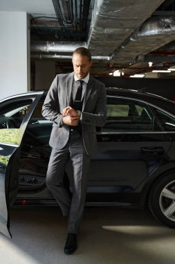 good looking bearded man in elegant suit posing next to his car on parking lot, business concept clipart