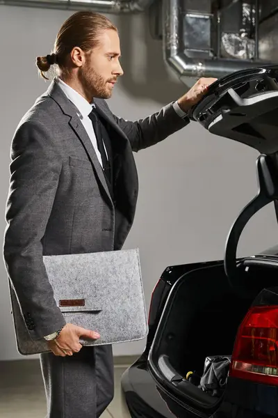 stock image vertical shot of handsome man with ponytail in neat suit closing trunk of his car, business concept