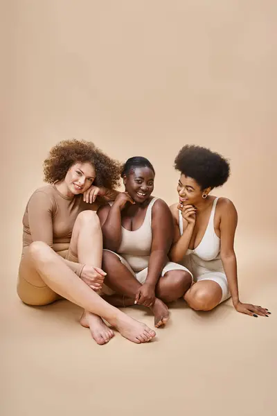 Alegre Cuerpo Multiétnico Mujeres Positivas Lencería Sentado Sonriendo Beige Autoestima —  Fotos de Stock
