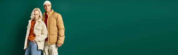 баннер стильных мужчин и женщин в пиджаках, позирующих вместе на бирюзовом фоне