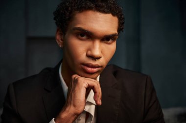 appealing good looking african american male model in elegant suit posing and looking at camera clipart
