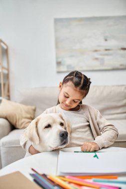 little girl in casual clothes drawing and hugging labrador in modern living room, art and leisure clipart