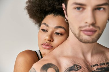 Çekici Afrikalı Amerikalı kadın. Arkasından yakışıklı erkek arkadaşına sımsıkı sarılıyor. Seksi çift.