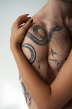 cropped view of african american woman hugging warmly her young tattooed boyfriend, sexy couple clipart