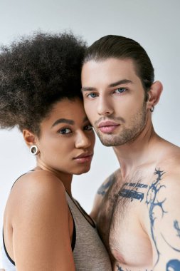 Çok kültürlü seksi bir çift iç çamaşırlarıyla birbirlerine poz veriyorlar ve birbirlerine sıkıca sarılıyorlar.