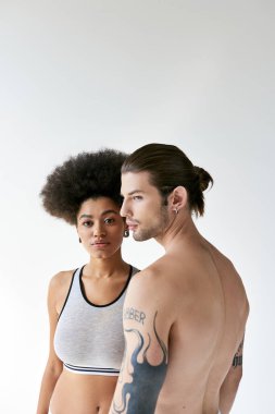 İç çamaşırlı güzel Afrikalı Amerikalı kadın genç erkek arkadaşı ve seksi çiftiyle poz veriyor.