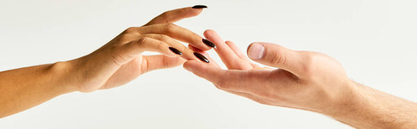 cropped view of young couple touching hands and fingers of each other on ecru background, banner