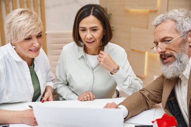 middle aged bearded realtor showing contract to lesbian couple in real estate office, lgbt couple clipart