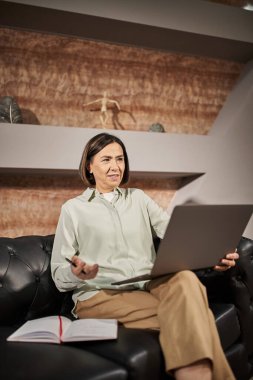 multiracial middle aged psychologist talking to client during consultation on laptop, online session clipart