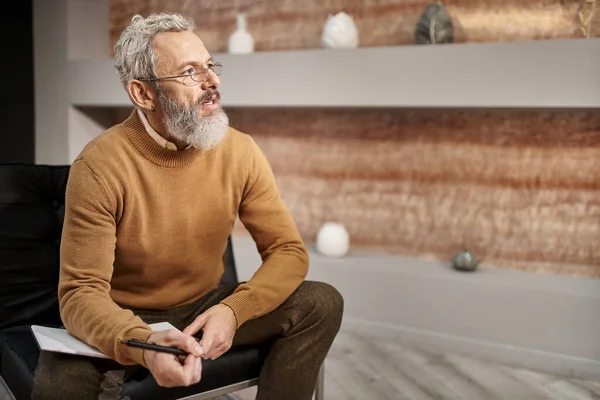 Gözlüklü Orta Yaşlı Bir Psikolog Defter Yanında Kalem Tutuyor Oturum — Stok fotoğraf