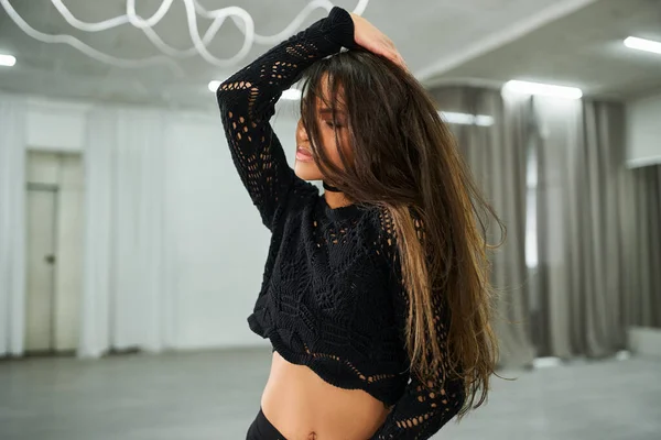 sensual african american dancer in black knitted sweater rehearsing in spacious dancing hall