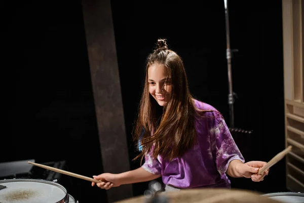 stock image cheerful adorable talented teen in vivid everyday outfit playing guitar and smiling happily