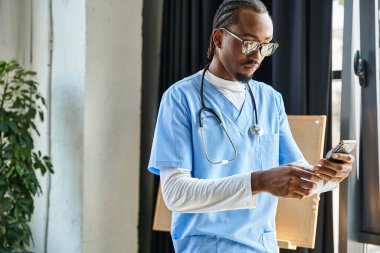 Steteskoplu yakışıklı Afro-Amerikan doktor cep telefonuna, teletıp