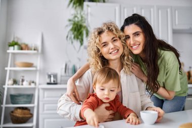 Ev elbiseli neşeli Igbt çifti kahvaltıda kızlarıyla harika vakit geçiriyorlar.