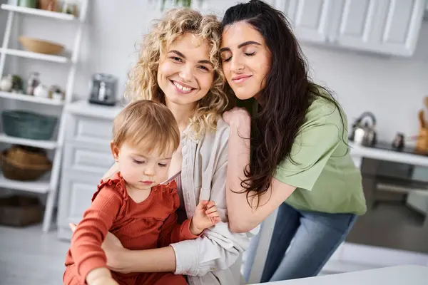 Neşeli, çekici lezbiyen çift, küçük kızlarıyla vakit geçiriyor. Aile kavramı.