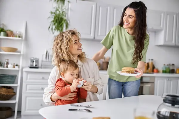 stock image happy attractive lgbt couple in homewear having great time with their daughter at breakfast, family