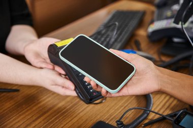 Kesilmiş Afrikalı Amerikalı kadın otel resepsiyonunda cep telefonu kullanıyor, seyahat ediyor.