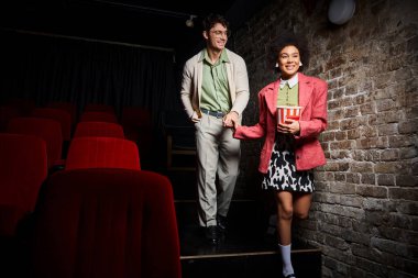 Eski moda giysiler içinde mutlu bir çift sinemada sevgililer gününde el ele tutuşuyor.