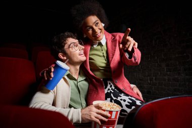 Gözlüklü neşeli adam sevgililer gününde Afrikalı Amerikalı kız arkadaşına mutlu bir şekilde bakıyor.