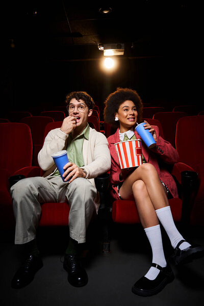 joyous young multiethnic couple in retro attires enjoying their date at cinema on Valentines day