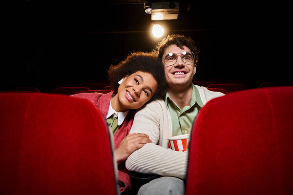 cheerful african american woman with her head on shoulder of her handsome boyfriend at cinema