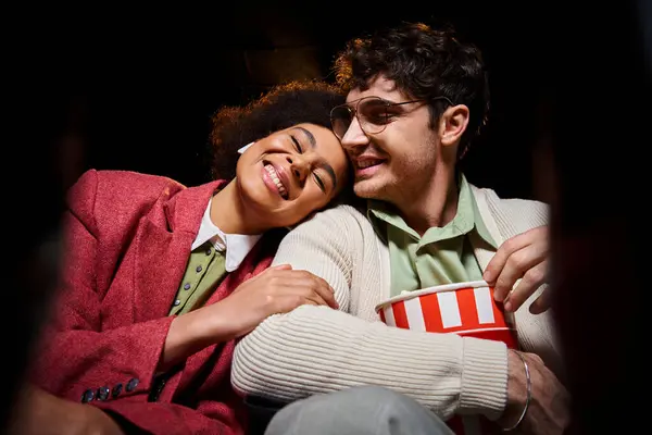 Çekici, neşeli, çok kültürlü çift sevgililer gününde sinemada harika vakit geçiriyorlar.
