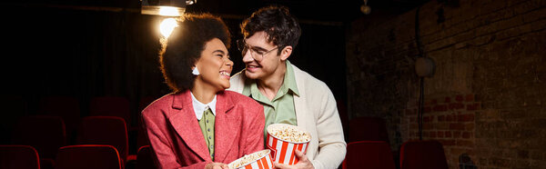 multiethnic joyful couple smiling at each other lovingly on date at cinema, Valentines day, banner