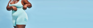 Mavi arka planda bisiklet şortlu, geniş beden spor afişi, vücut pozitifliği.