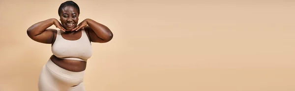 幸せなプラスサイズのアフリカ系アメリカ人女性は マッチングバックドロップ バナーと彼女の顔の近くに手で — ストック写真