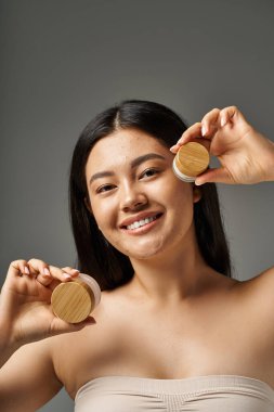 young asian woman with brunette hair and acne prone skin looking at mirror in bathroom, banner clipart