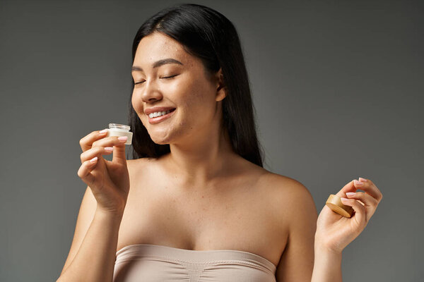 молодая азиатка с брюнетками и прыщавой кожей, смотрящая на зеркало в ванной комнате, баннер