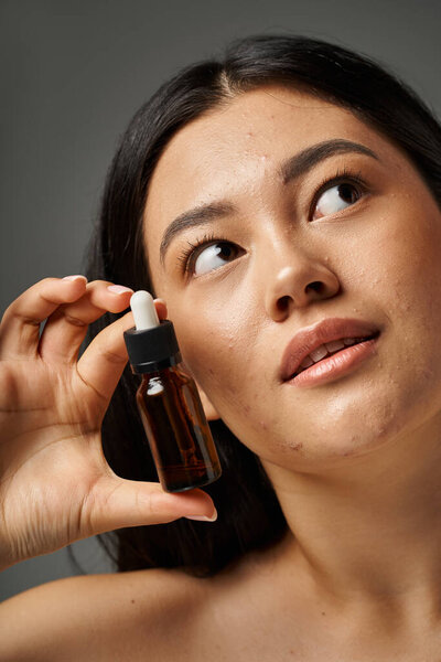 молодая азиатка с брюнетками и прыщавой кожей, смотрящая на зеркало в ванной комнате, баннер