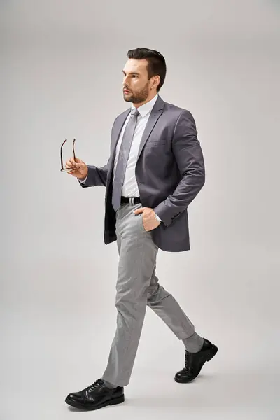 Hombre Negocios Confiado Ropa Formal Sosteniendo Gafas Caminando Con Mano —  Fotos de Stock