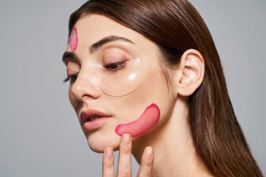 A young Caucasian woman with brunette hair has pink patches on her face, creating a vibrant and artistic look. clipart