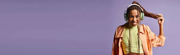 Счастливая Африканская Американская Молодая Женщина Наушниках Держа Свои Дреды Фиолетовом — стоковое фото