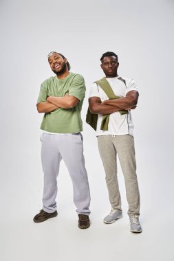 Juneteenth concept, two african american friends standing with folded arms on grey background clipart