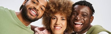 positive african american friends looking at camera on grey background, Happy Juneteenth banner clipart