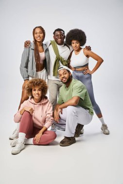 cheerful african american people in sportswear standing together on grey backdrop, Juneteenth clipart