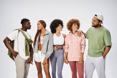 Spor giyimli bir grup genç Afro-Amerikan Gri arka planda, toplulukta birlikte duruyorlar.