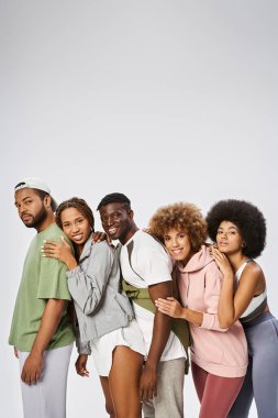 Gri arka planda bir arada duran bir grup pozitif genç Afrikalı Amerikalı