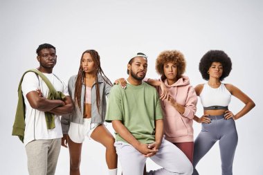 group of positive young african american friends posing together on grey background, community clipart