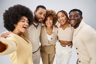 Bir grup gülümseyen Afrikalı Amerikalı arkadaş gri arka planda sarılıp kaynaşıyorlar, Juneteenth.