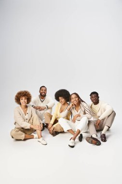 group of smiling african american friends in casual attire sitting on grey background, Juneteenth clipart
