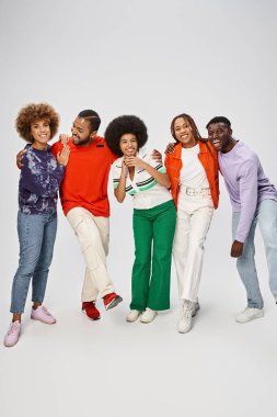 cheerful african american community in colorful casual wear standing together on grey background clipart