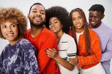 cheerful african american community in casual attire hugging each other on grey backdrop, Juneteenth clipart
