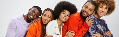 Mutlu Afro-Amerikan toplumu günlük kıyafetleriyle birbirlerine yaslanıyorlar, Haziran bayrağı.
