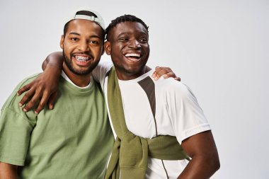 Neşeli Afro-Amerikan erkek arkadaşları gri arka planda sarılıyorlar, Juneteenth