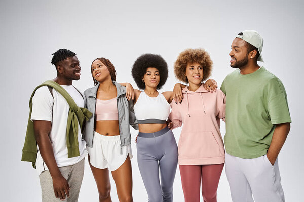 группа веселых молодых африканских американских друзей, стоящих вместе на сером фоне, сообщество